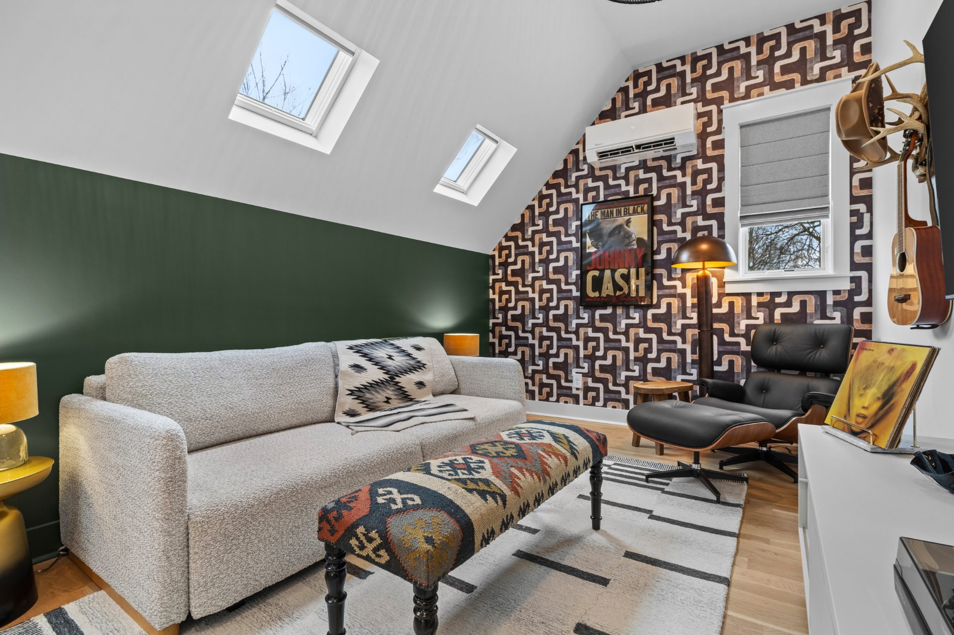 Bright, welcoming Nashville loft living room with a cream boucle sofa, patterned accents, and a green feature wall