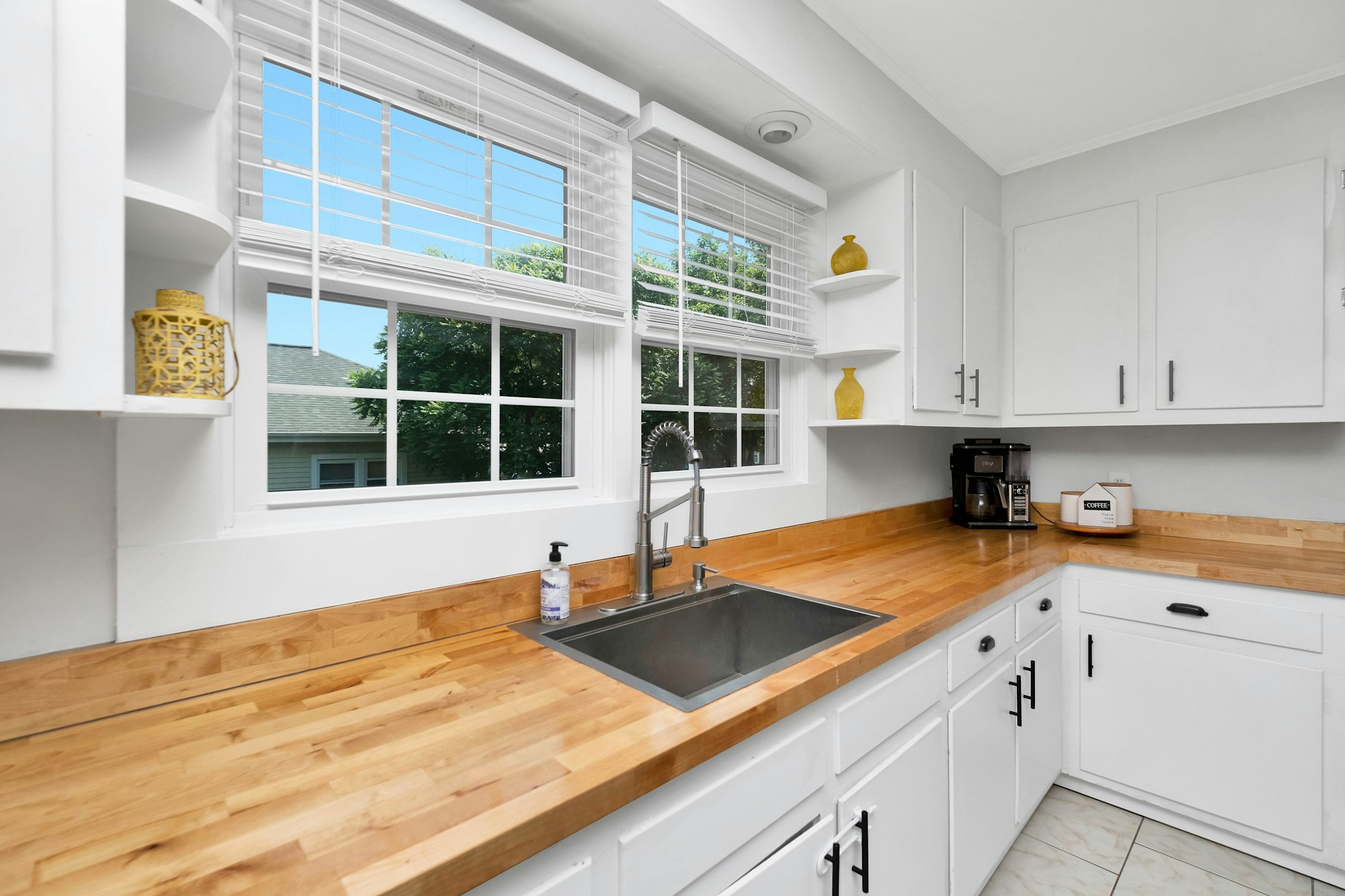 Bright kitchen with white cabinets and a sink