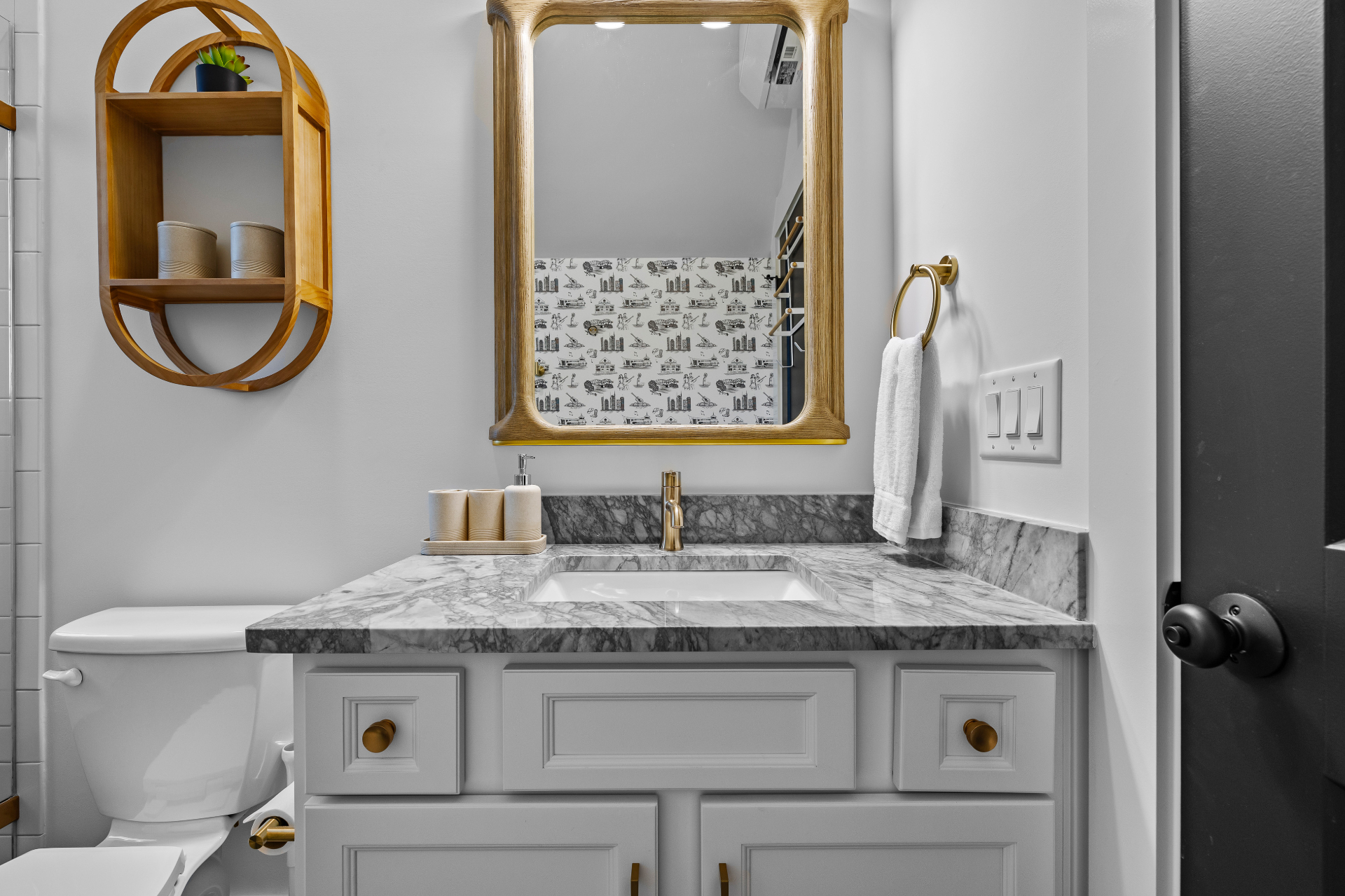 Marble bathroom vanity with brass fixtures in a Nashville above-garage apartment short-term rental