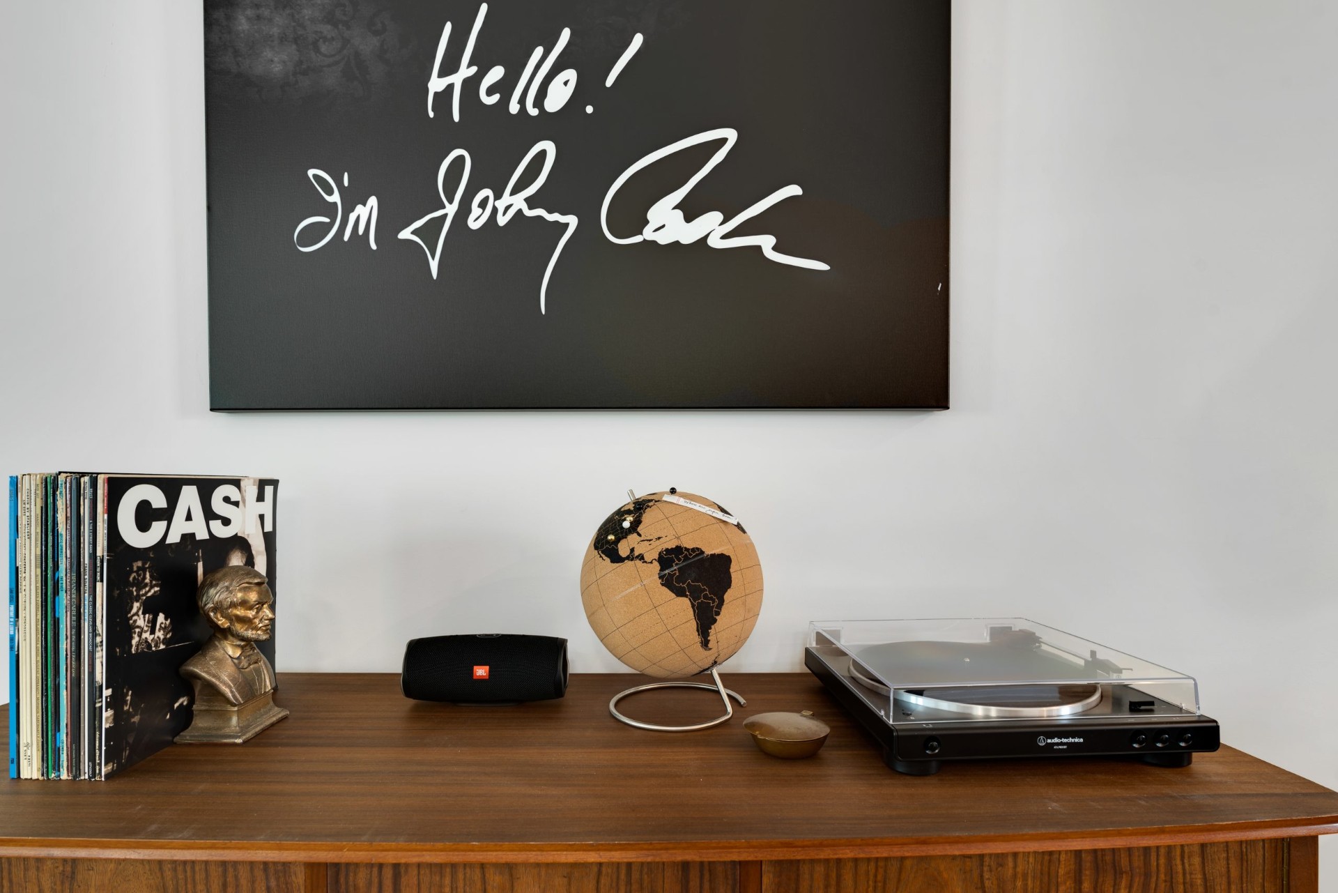 Console styled with vinyl records, a Johnny Cash canvas, and a turntable in a two-bedroom Nashville townhome short-term rental